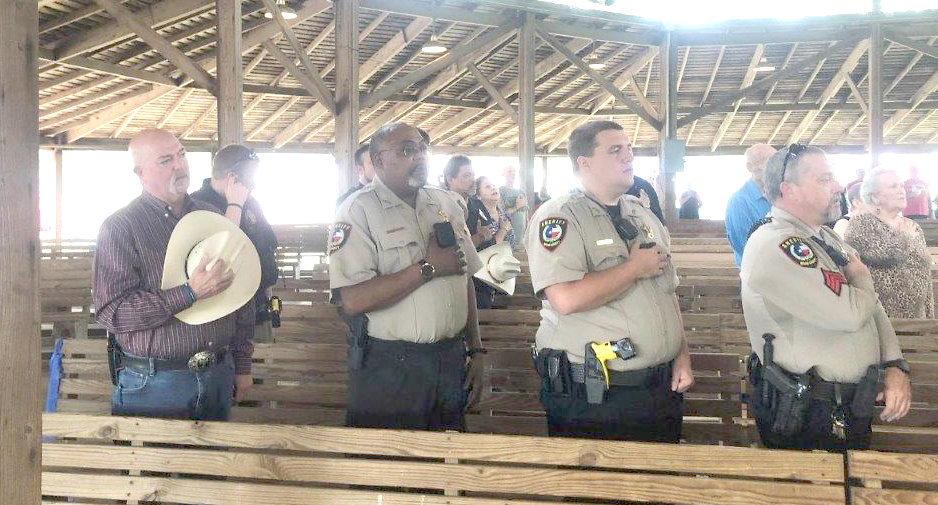 Wood County Sheriff Kelly Cole, Deputy A.G. Sessions, Deputy Cody Burge and Sgt. Lyn Bettis recite the Pledge of Allegiance at Local Heroes Day held during the “Sunday Market in the Park” at Jim Hogg City Park in Quitman Sunday.